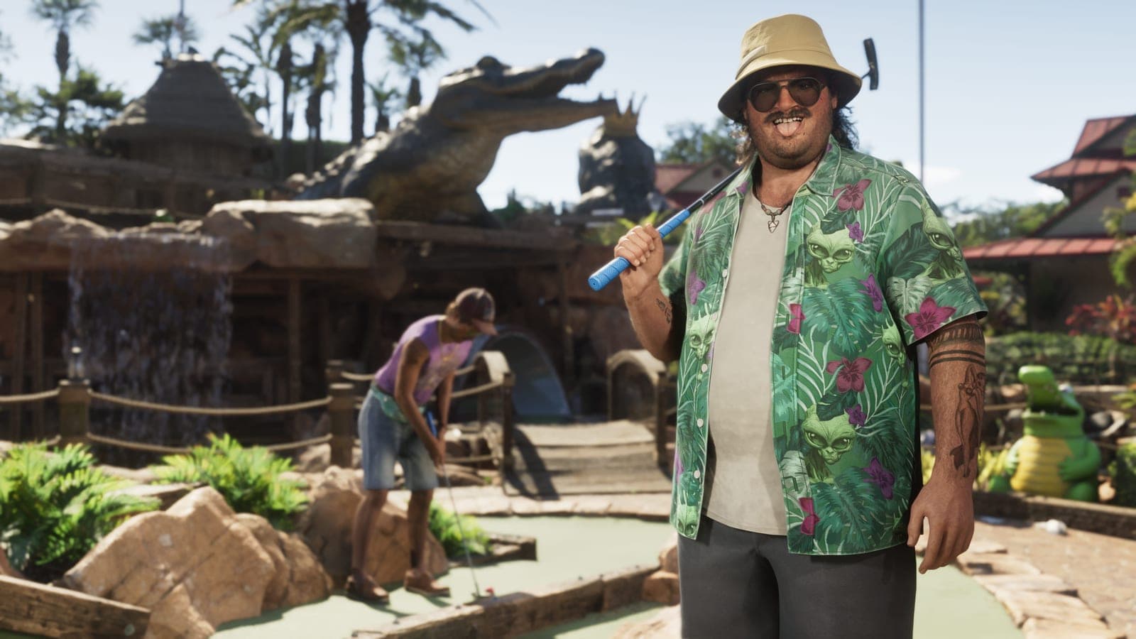 A man in a bucket hat and sunglasses holding a putter on a crazy golf course, a large alligator statue rearing up behind him and a small cartoon alligator by the green.