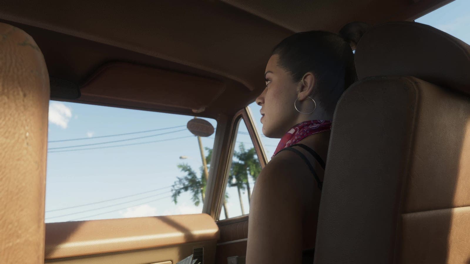 Lucia Caminos in the passenger seat of a car, looking across at the driver.