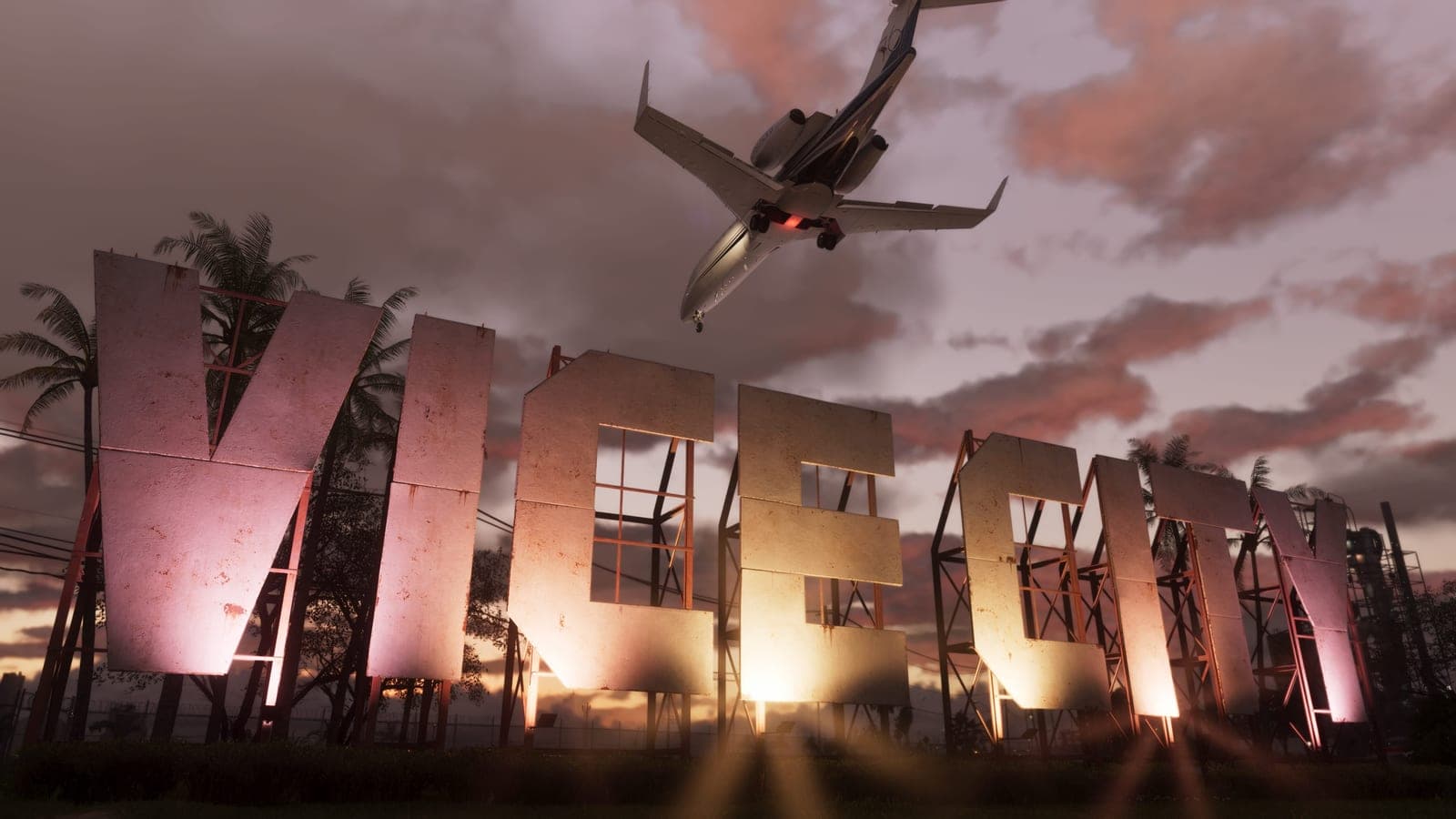 A row of giant weathered letters spelling VICE CITY standing on scaffolding against a pink sunset, a private jet passing low overhead.